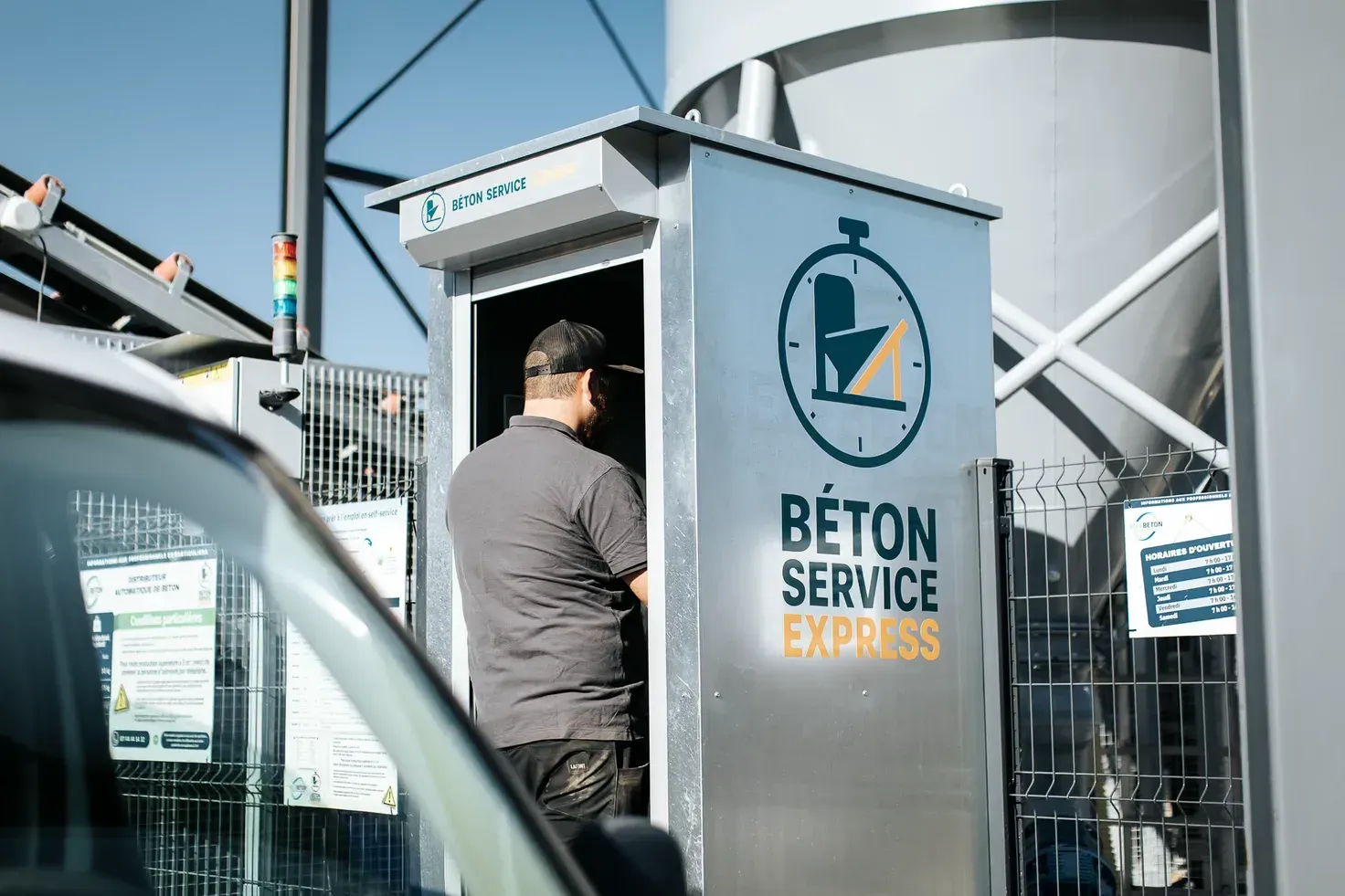 Utilisateur devant la borne de commande du distributeur automatique de béton